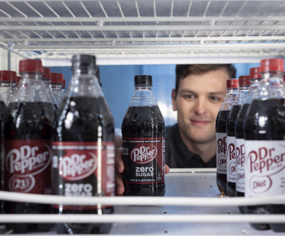 Someone reaching into a cooler filled with Dr. Pepper